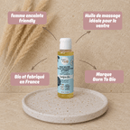 Présentation de huile de massage pour le ventre Born to bio idéale pour la grossesse, posée sur un présentoir en travertin