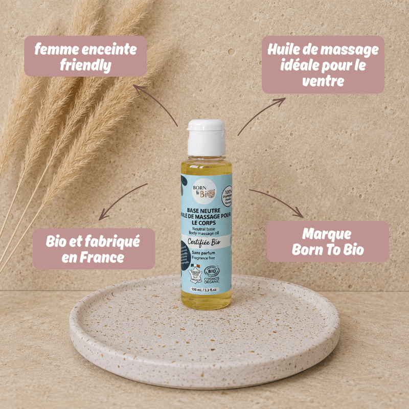 Présentation de huile de massage pour le ventre Born to bio idéale pour la grossesse, posée sur un présentoir en travertin