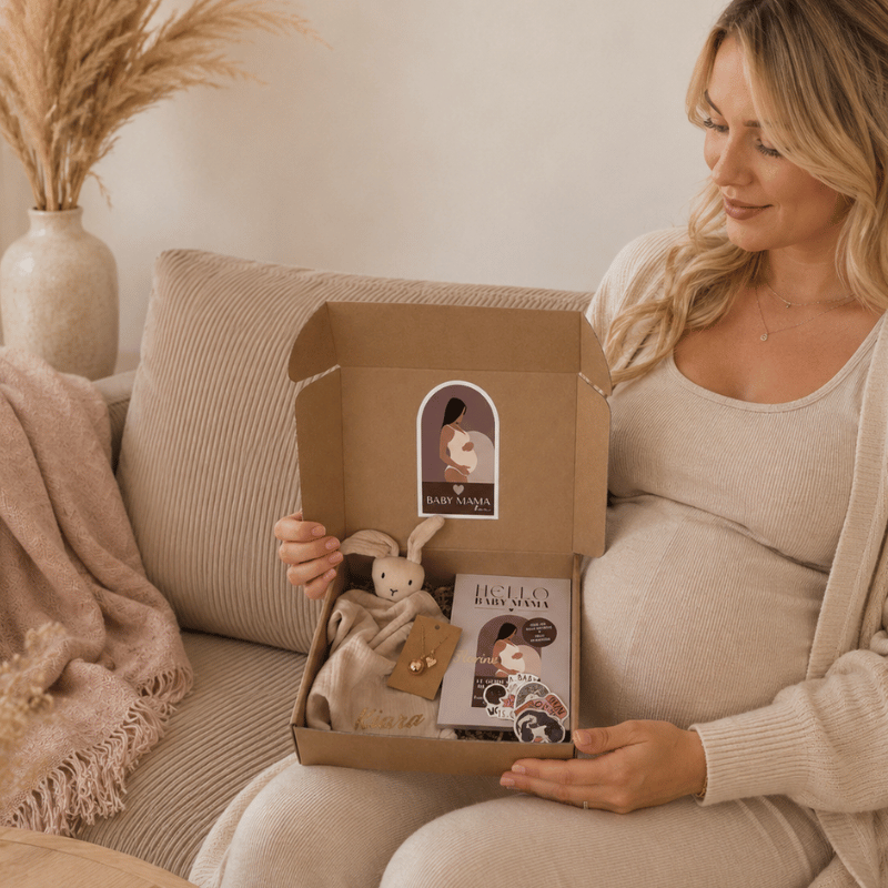 coffret trio Baby mama Box tenu par une femme enceinte contenant un doudou personnalisé, un bola et un guide Hello Baby Mama